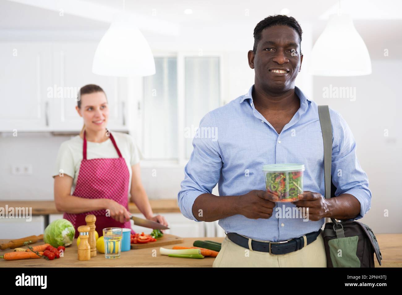 Portrait of positive man with lunch box Stock Photo - Alamy