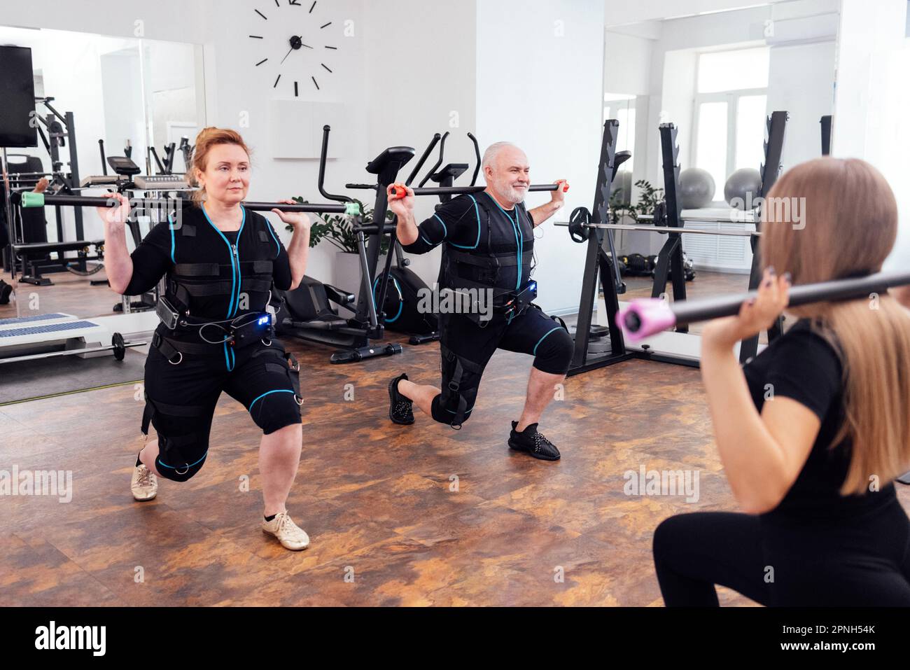 Eldery couple in ems suits doing electrical muscle stimulation workout
