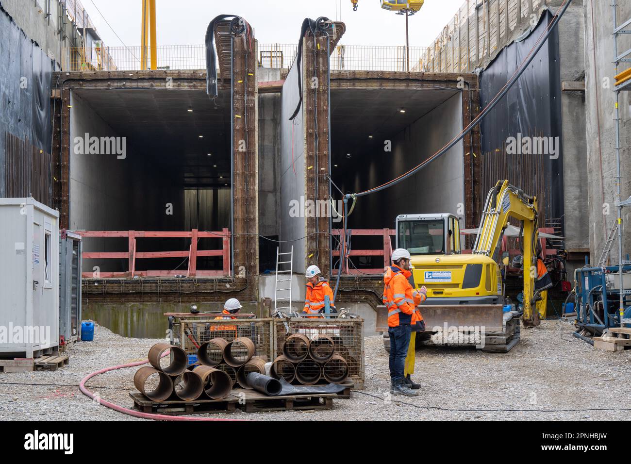 19 April 2023, Bavaria, Munich: Workers stand on the construction site ...