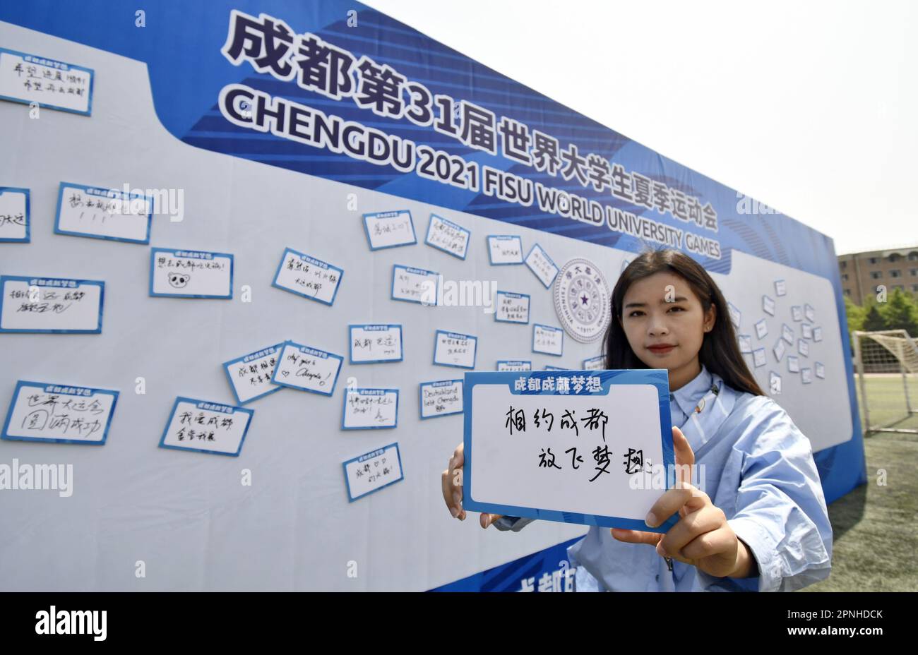 (230419) -- BEIJING, April 19, 2023 (Xinhua) -- A student of Tsinghua University poses with a handwritten message card with her wishes for Chengdu during an event in celebration of the 100-day countdown to the Chengdu 2021 FISU World University Games at Tsinghua University in Beijing, capital of China, April 19, 2023. (Xinhua/Li Xin) Stock Photo