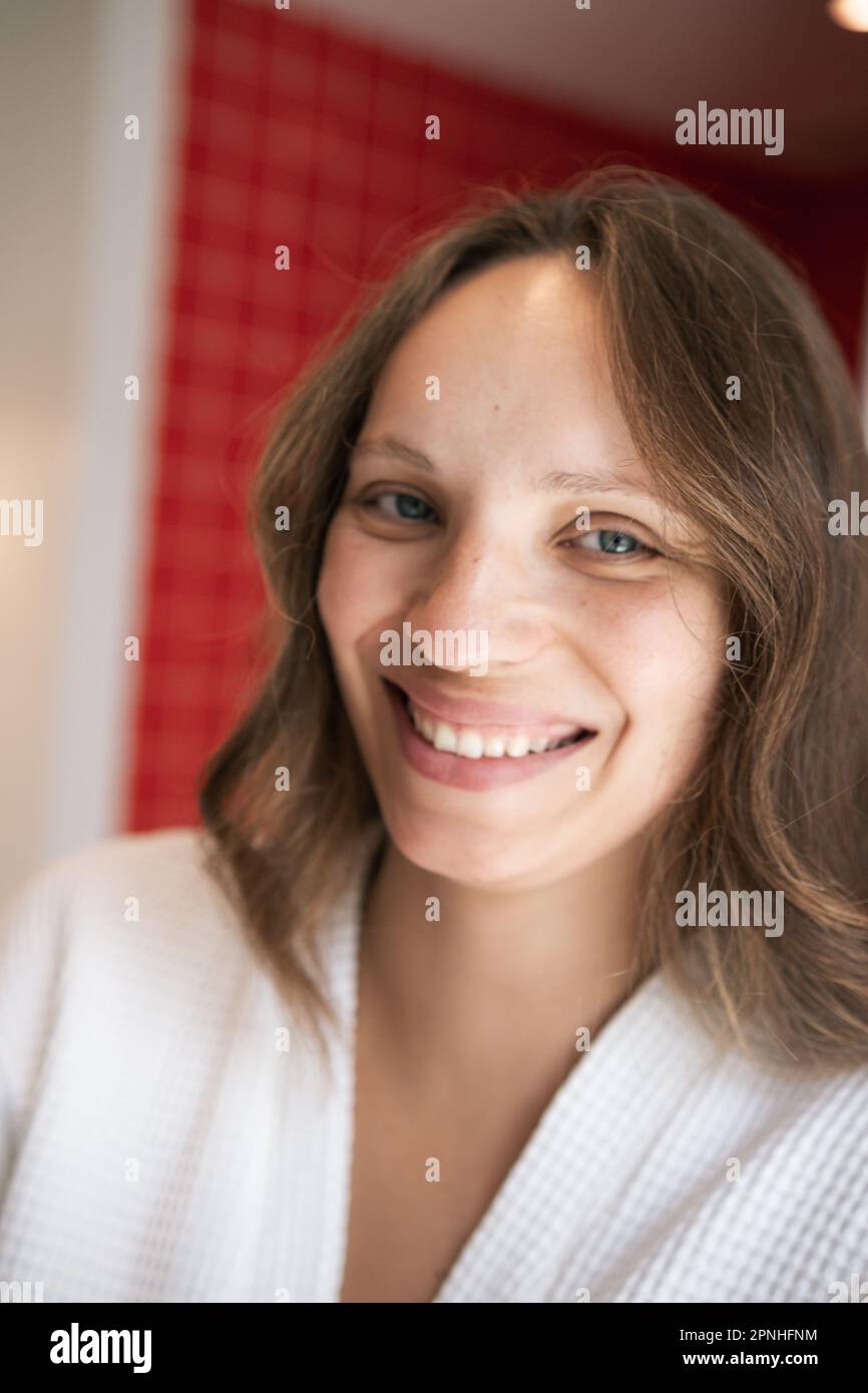 Skincare routine white female in a bright bathroom shaving legs with a