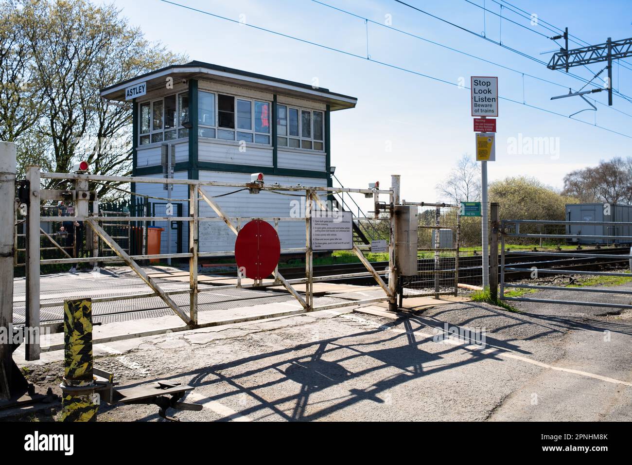 Level crossing gates on the train tracks and signal box Astley Barton