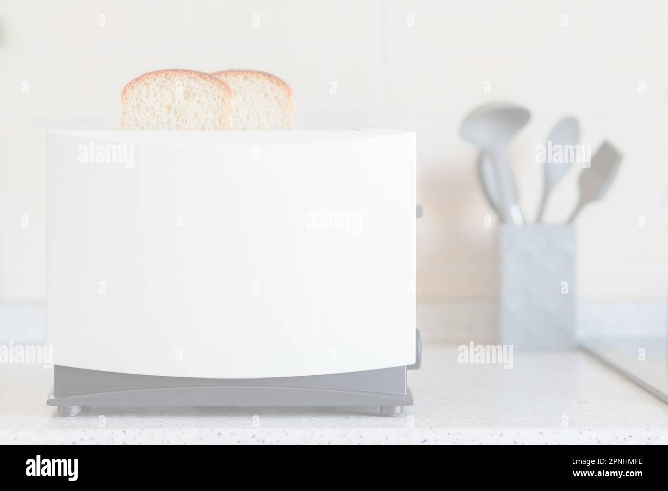 Light overexposed kitchen background with toaster and kitchen utensils on the table Stock Photo