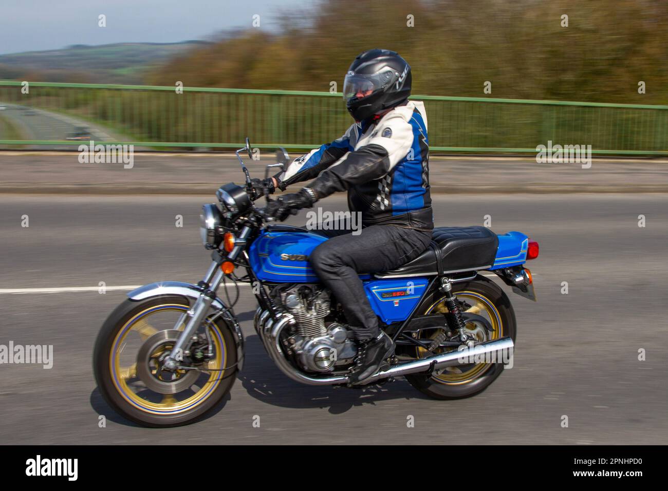 1980 80s eighties Suzuki Inline Four Blue Motorcycle Roadster Petrol 549 cc; crossing motorway bridge in Greater Manchester, UK Stock Photo