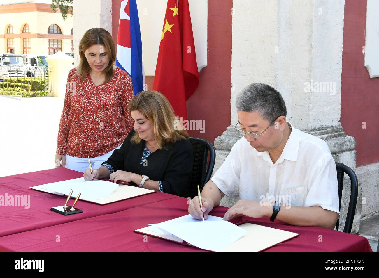 (230419) -- HAVANA, April 19, 2023 (Xinhua) -- Chinese Ambassador to Cuba Ma Hui (R) and Cuba's Deputy Minister of Foreign Trade and Investment Deborah Rivas sign handover documents at Cuba's National Institute of Hydraulic Resources (INRH) in Havana, Cuba, April 18, 2023. Cuba's National Institute of Hydraulic Resources (INRH) on Tuesday welcomed a donation from the Chinese government to help the Caribbean island weather a severe drought. China donated 449 pieces of equipment, including trucks, bulldozers, lighting towers, backhoe loaders, motor graders, and thermal diffusion welding machin Stock Photo