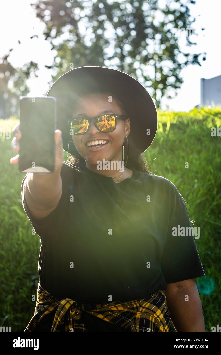 Close up portrait of happy african american young woman browsing social ...