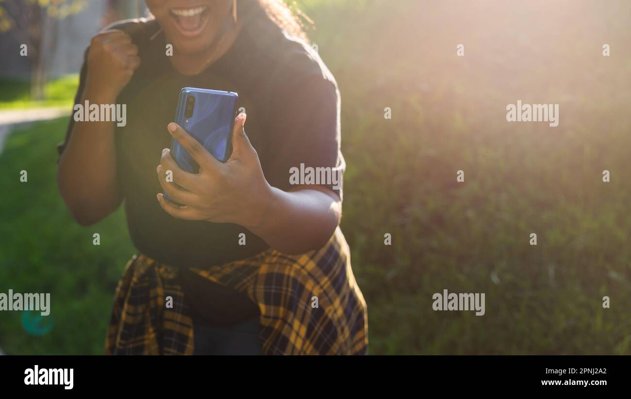 Close up portrait of happy african american young woman browsing social ...