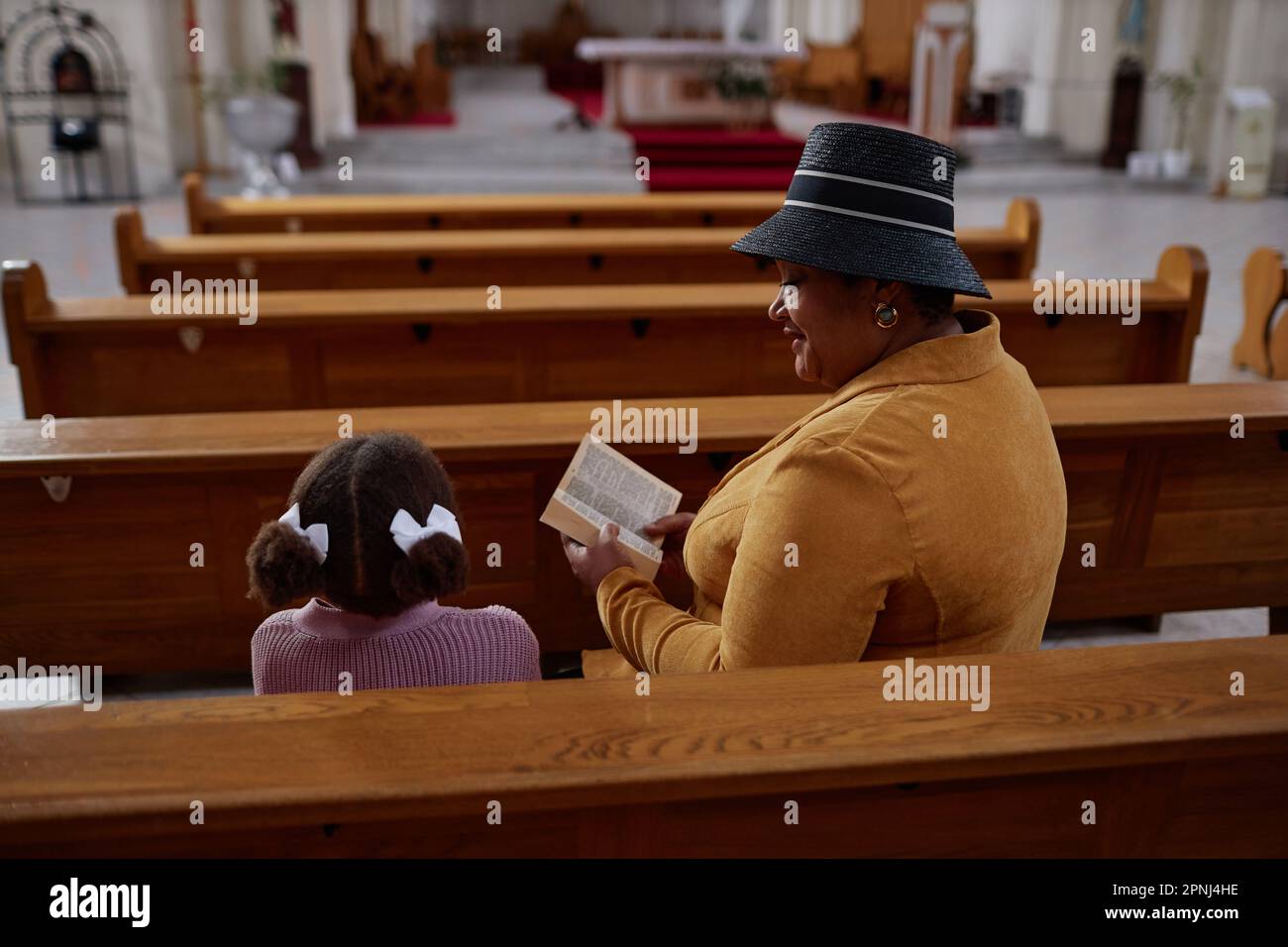 African American grandmother reading Bible to her granddaughter in ...