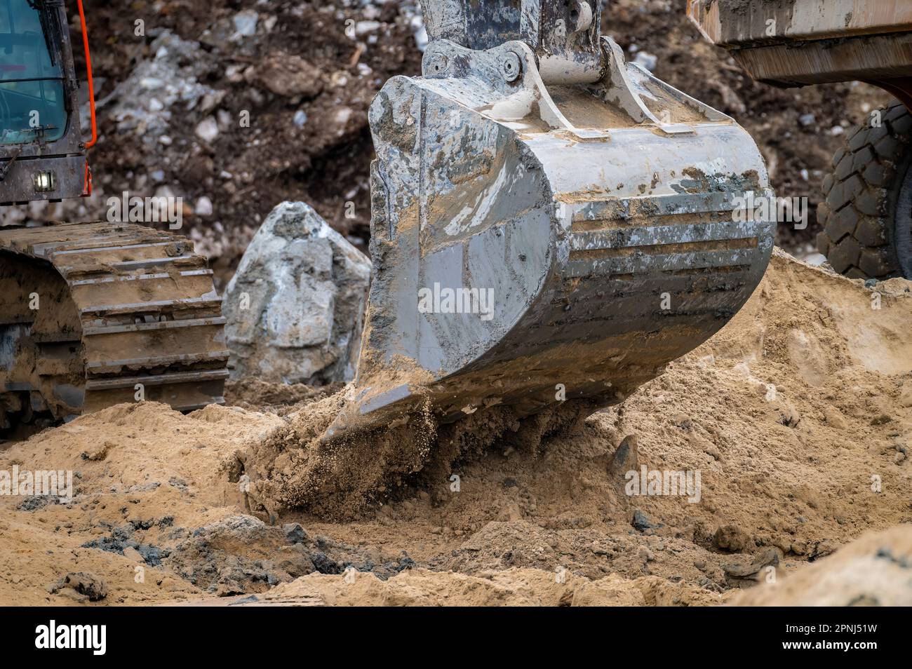 Close-up image of an excavator bucket emptying sand, motion Stock Photo