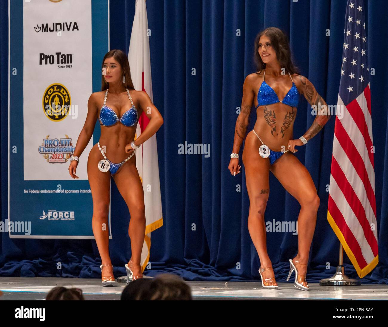 Yokota, Japan. 16 April, 2023. Two female bodybuilders pose on stage during the 2023 US - Japan Friendship Cup bodybuilding contest hosted by the 374th Force Support Squadron at Yokota Air Base, April 16, 2023 in Western Tokyo, Japan. Credit: A1C Jarrett Smith/U.S. Air Force/Alamy Live News Stock Photo
