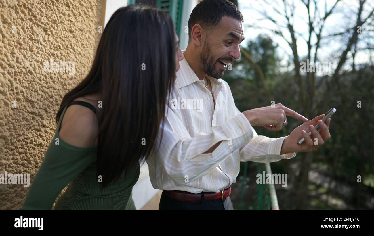 An Excited boyfriend calling for girlfriend sharing successful notification  message on cellphone device while standing outside at balcony. Happy girl  Stock Photo - Alamy