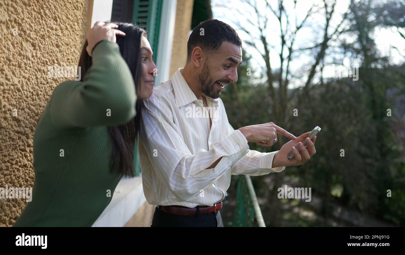 An Excited boyfriend calling for girlfriend sharing successful notification  message on cellphone device while standing outside at balcony. Happy girl  Stock Photo - Alamy