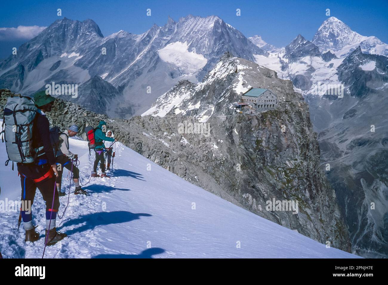 Climbers approach the Swiss Alpine Club hut Cabane Vignettes on the Chamonix to Zermatt Haute Route with the the mighty peak of Dent Blanche on the right Stock Photo