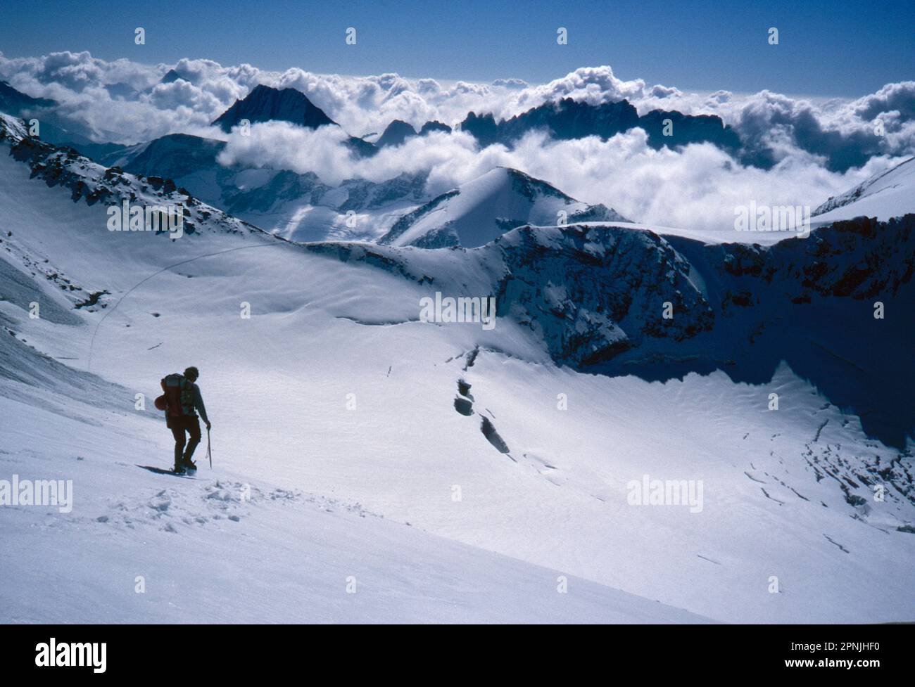 A lone climber passes over the Plateau Du'Couloir high alpine pass on the Chamonix to Zermatt Haute Route Stock Photo