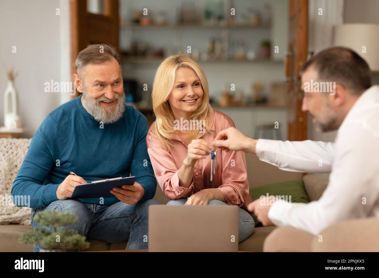 Real Estate Agent Giving New House Keys To Couple Indoors Stock Photo ...