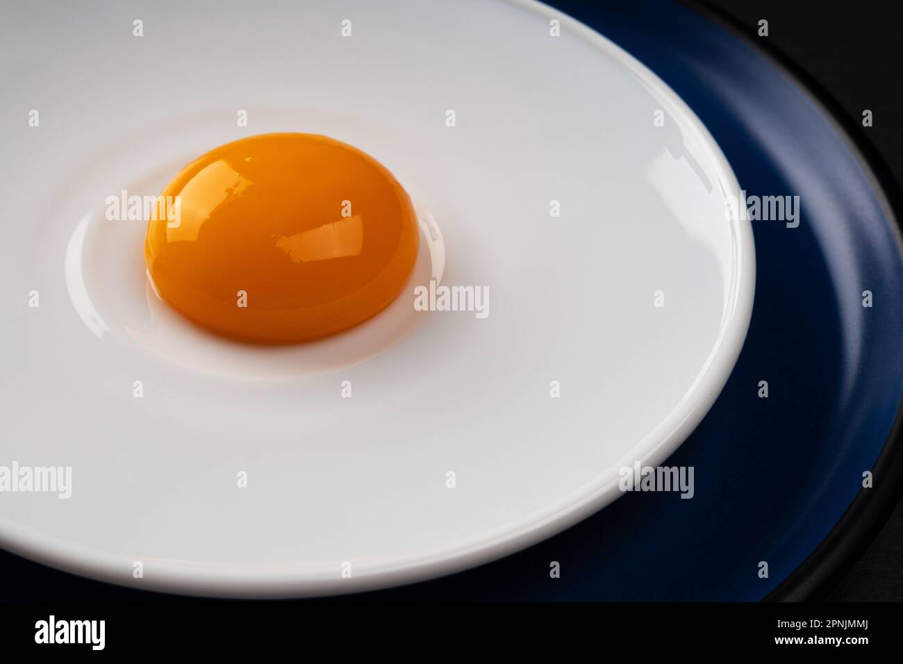 Egg yolk on the plate. Abstract fried eggs. Close up. Stock Photo