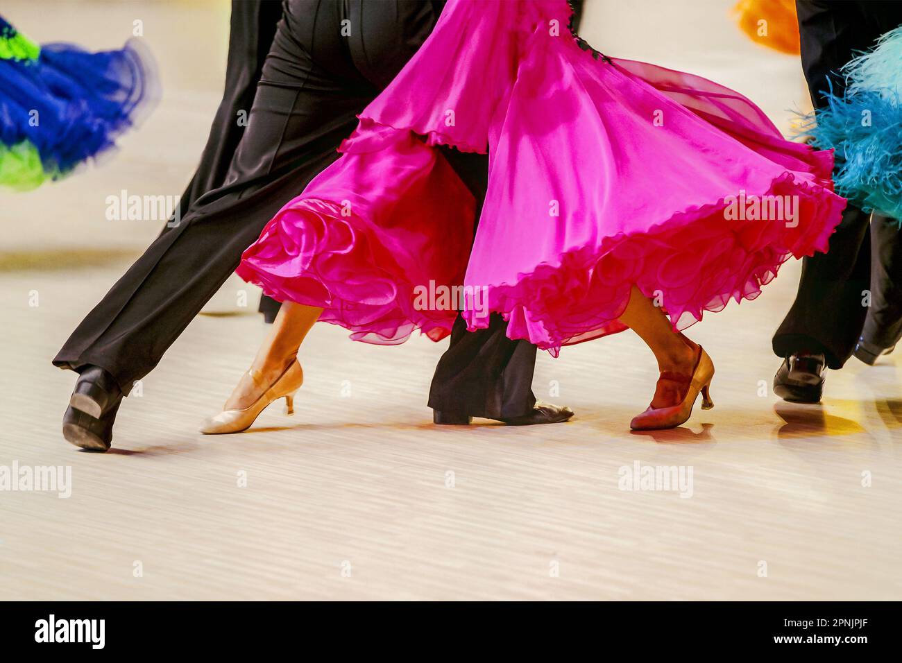 close-up part pink ball gown and and man black tail suit on dance floor Stock Photo