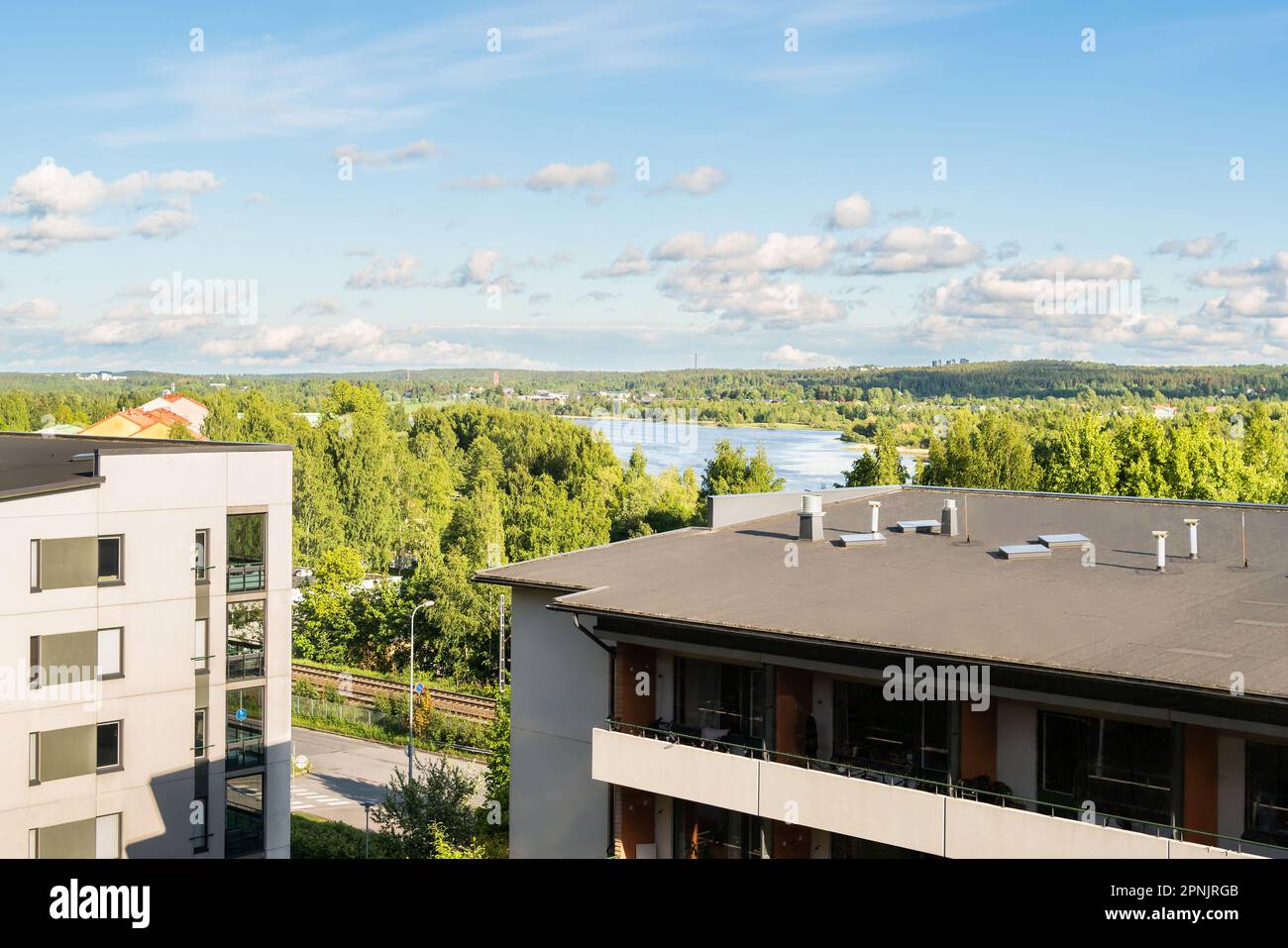 Building with apartments, condos in residential area. Park, green forest and lake landscape view. Outside facade of house. Rental housing. Stock Photo