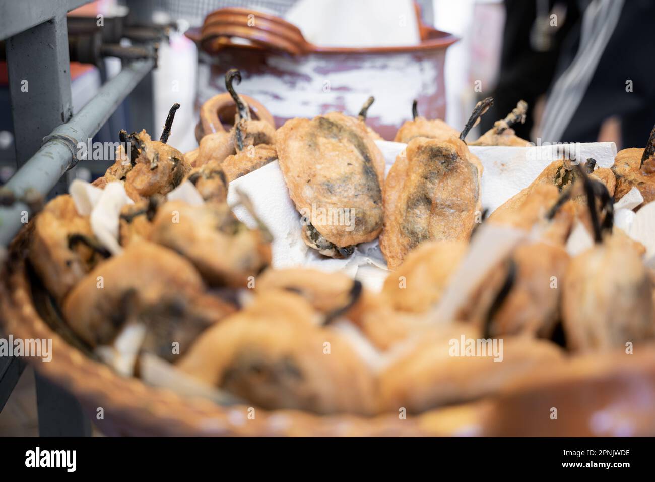 Some recently cooked battered poblano chillis inside of a big