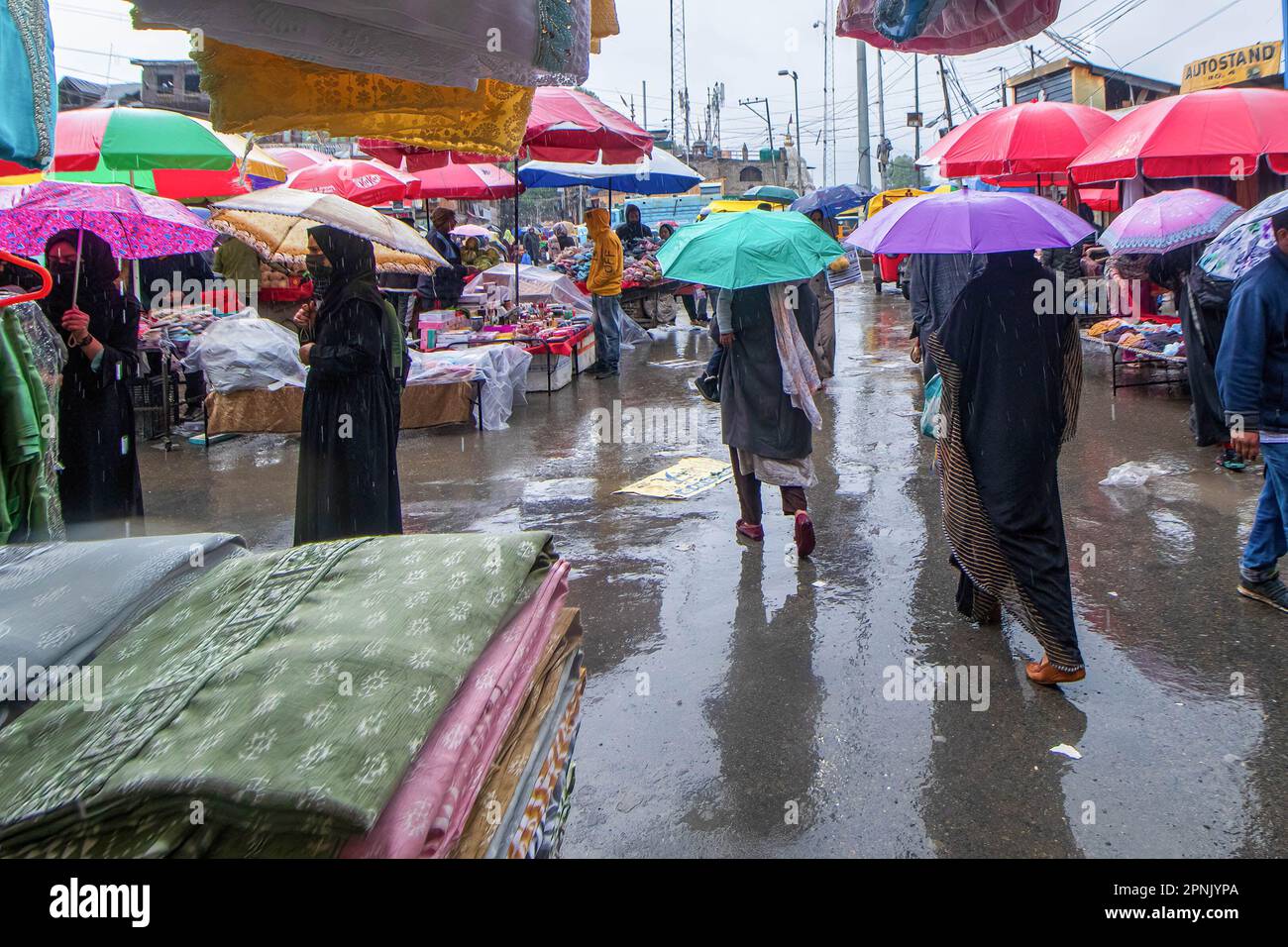 Kashmiri people seen shopping during rainfall ahead of the Muslim 