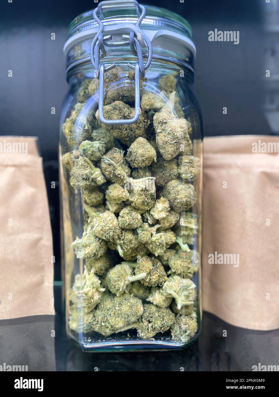 Glass jar full of Meical Cannabis Sativa against dark background Stock Photo