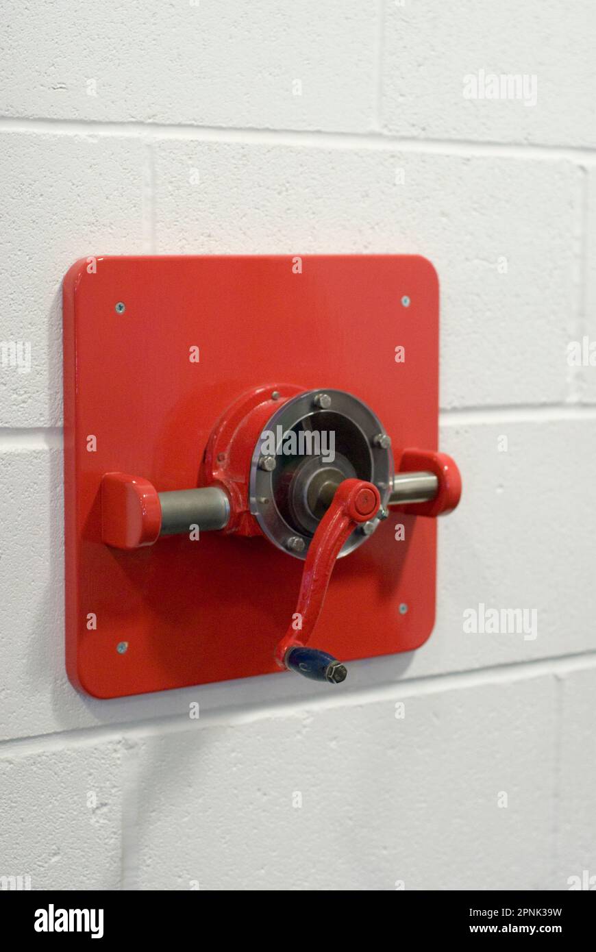 Red pump handle on wall Stock Photo Alamy