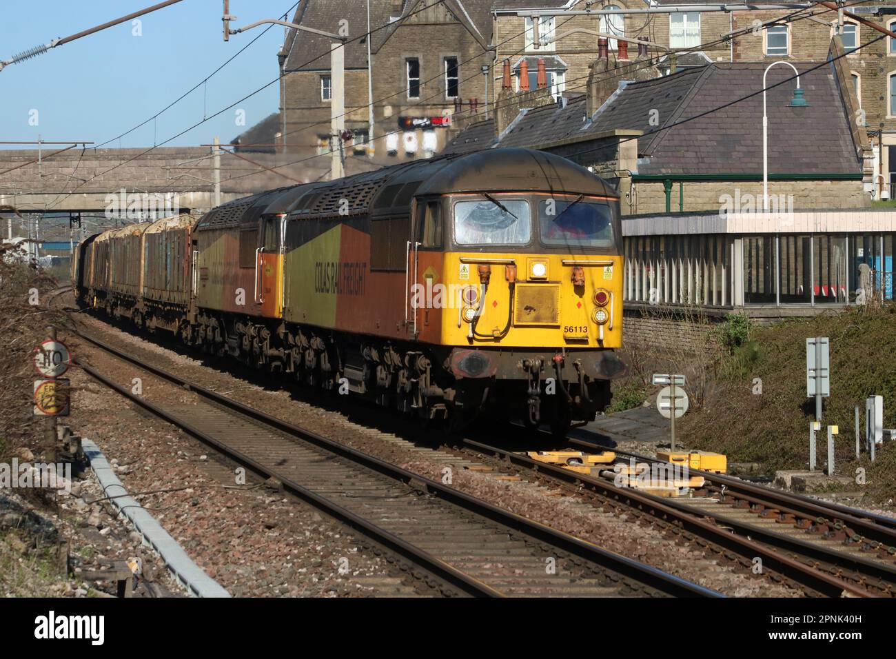 Colas Rail freight class 56 grid diesel-electric locos, 56113, 56049 double heading log train on West Coast Main Line at Carnforth on 19th April 2023. Stock Photo