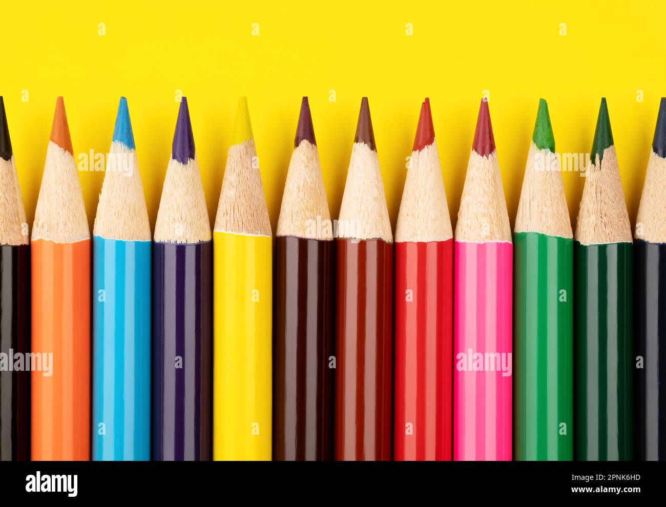 Colored pencils on a yellow background. Multi-colored pencils. Stock Photo
