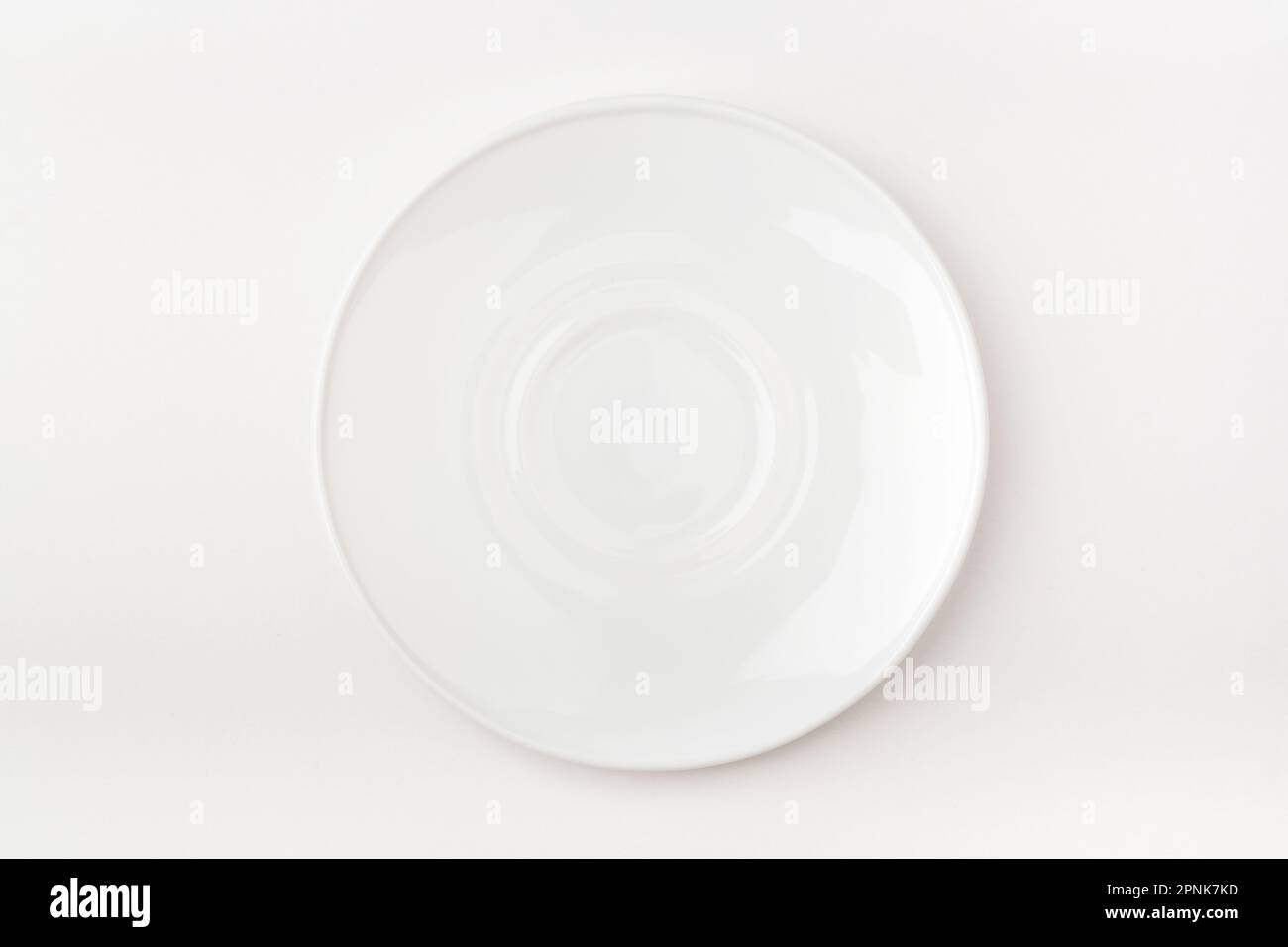 An empty white plate on a white background. Blank plate. Top view. Stock Photo