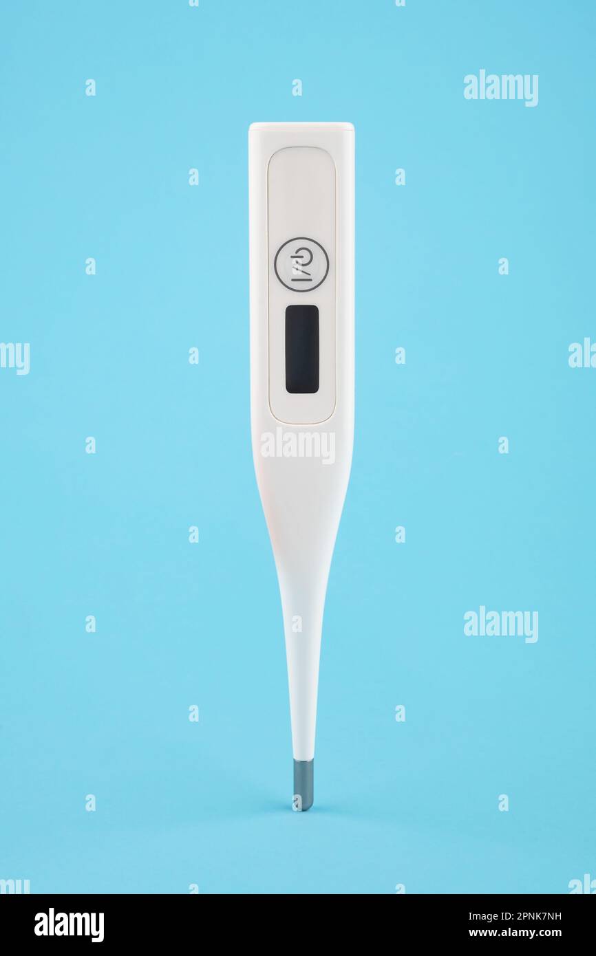 Digital thermometer levitating on a blue background. Stock Photo