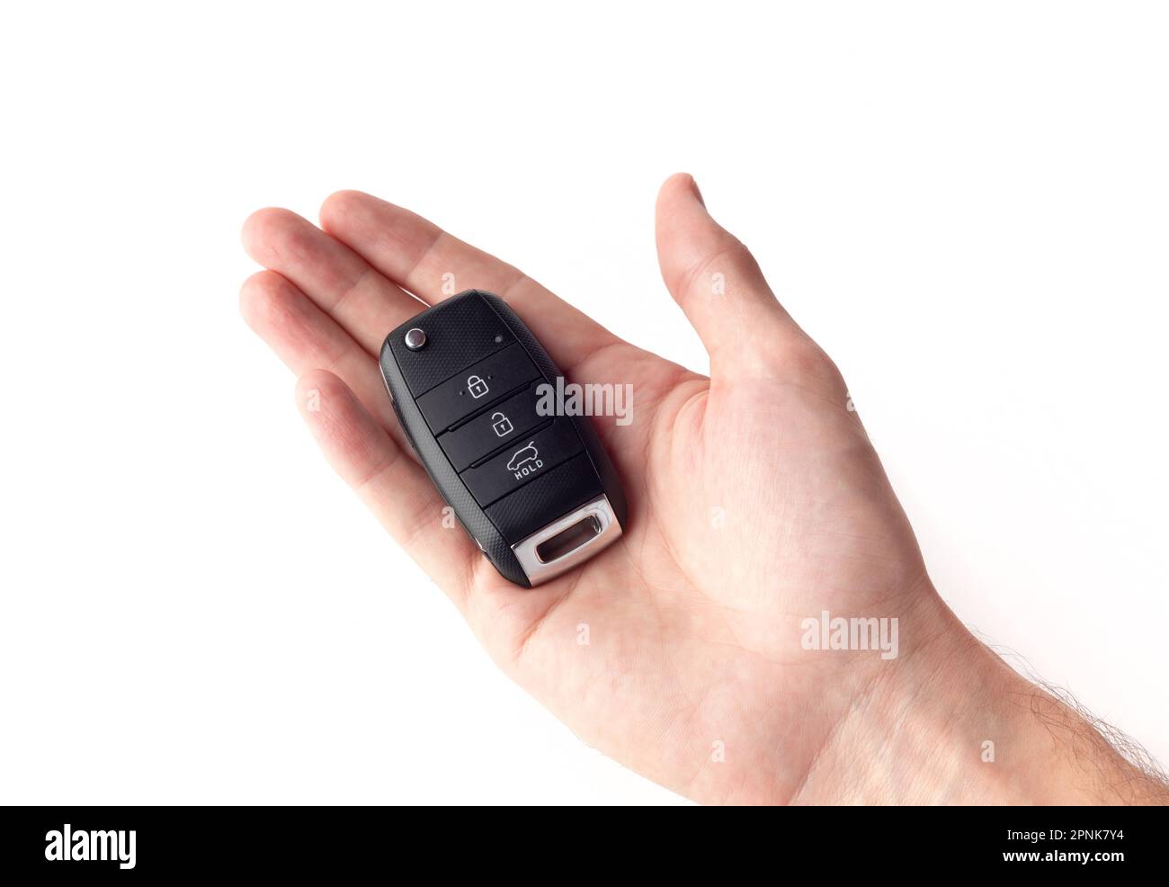 A man's hand holds the car key isolated on a white background close up. Stock Photo