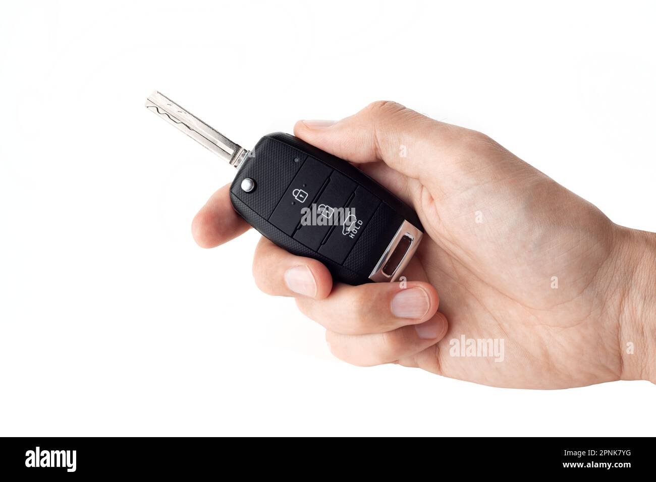 A man's hand holds the car key isolated on a white background close up. Stock Photo