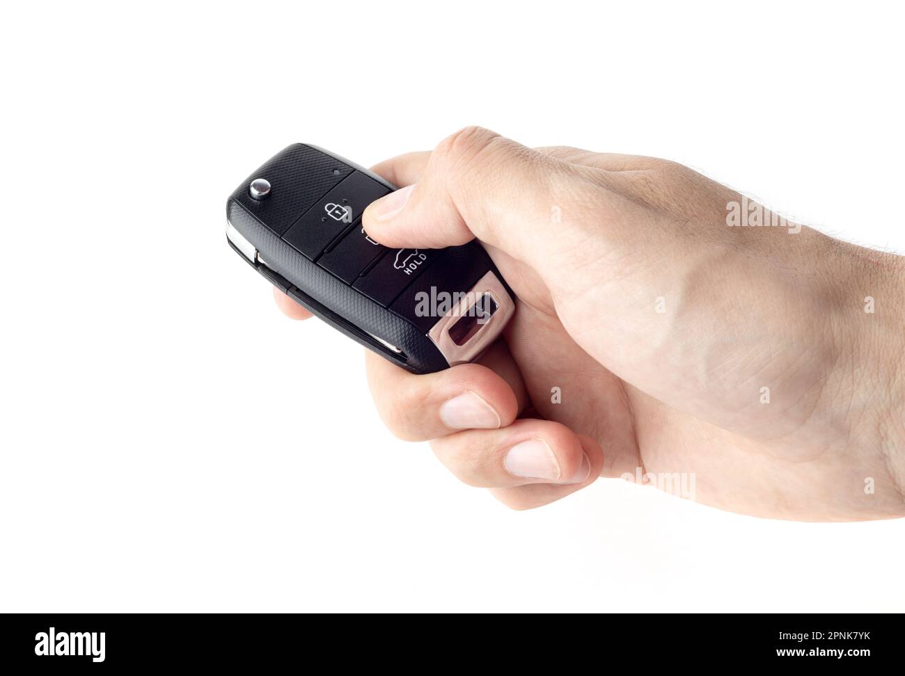 Unlocking a car with button on the keychain. Man's hand holds car key on white background close up. Stock Photo