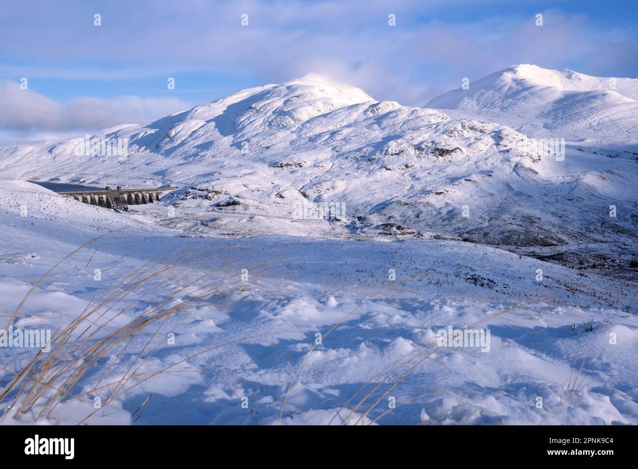 A January snowfall covers the slopes of Ben Lawers and Beinn Ghlas with a view of the Lawers Dam, Killin Scotland Stock Photo