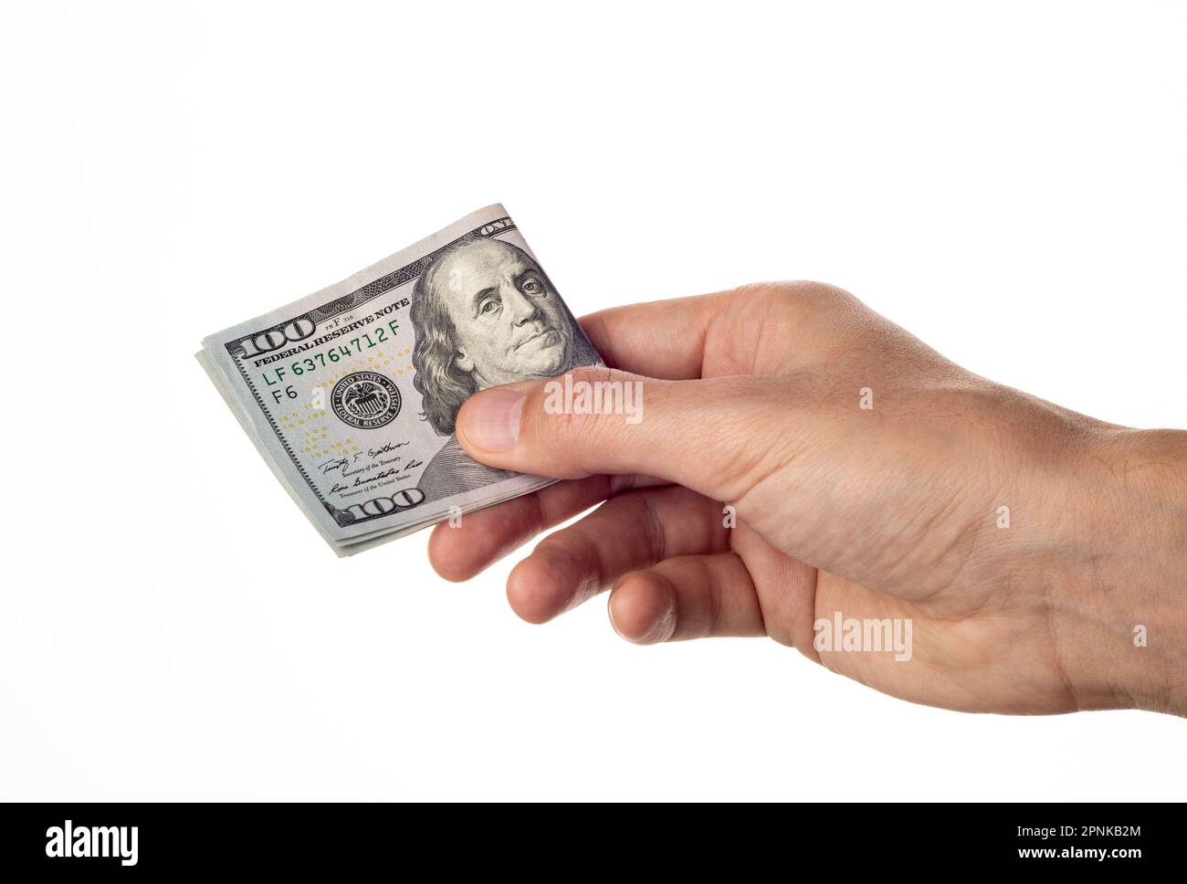 Man hand giving 100 dollar bills isolated on white background. One hundred us dollars Stock Photo