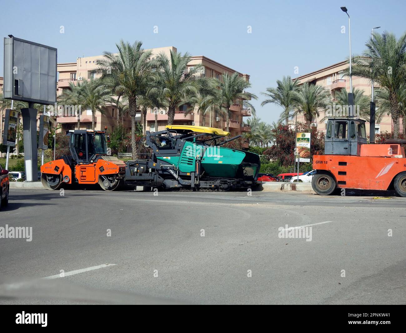 Cairo, Egypt, April 18 2023: Asphalt paver trucks and compactors, A paver (road paver finisher, asphalt finisher, road paving machine) is a piece of c Stock Photo