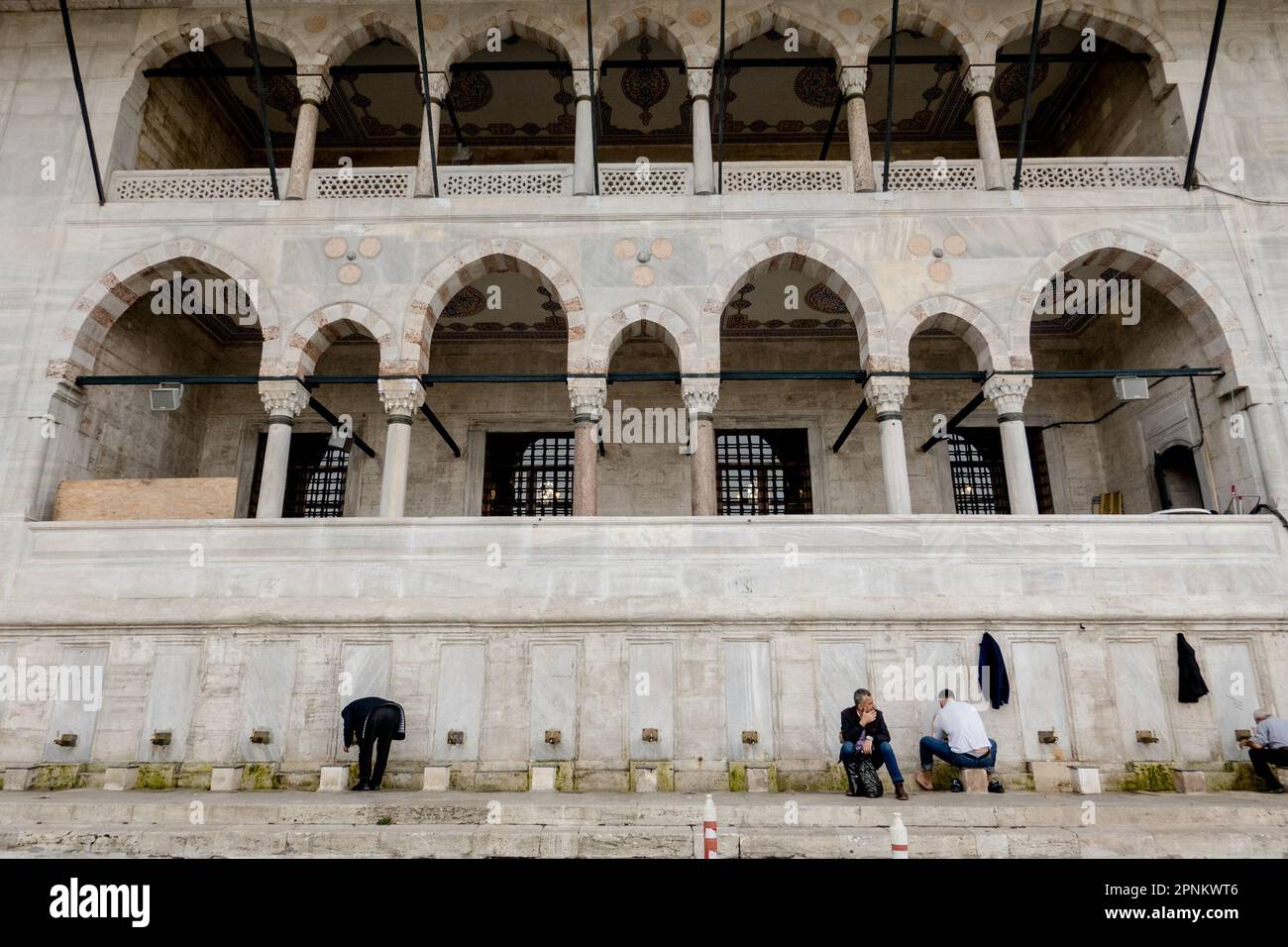 People prepare to enter, The Yeni Mosque, also known as the New Mosque, a striking example of