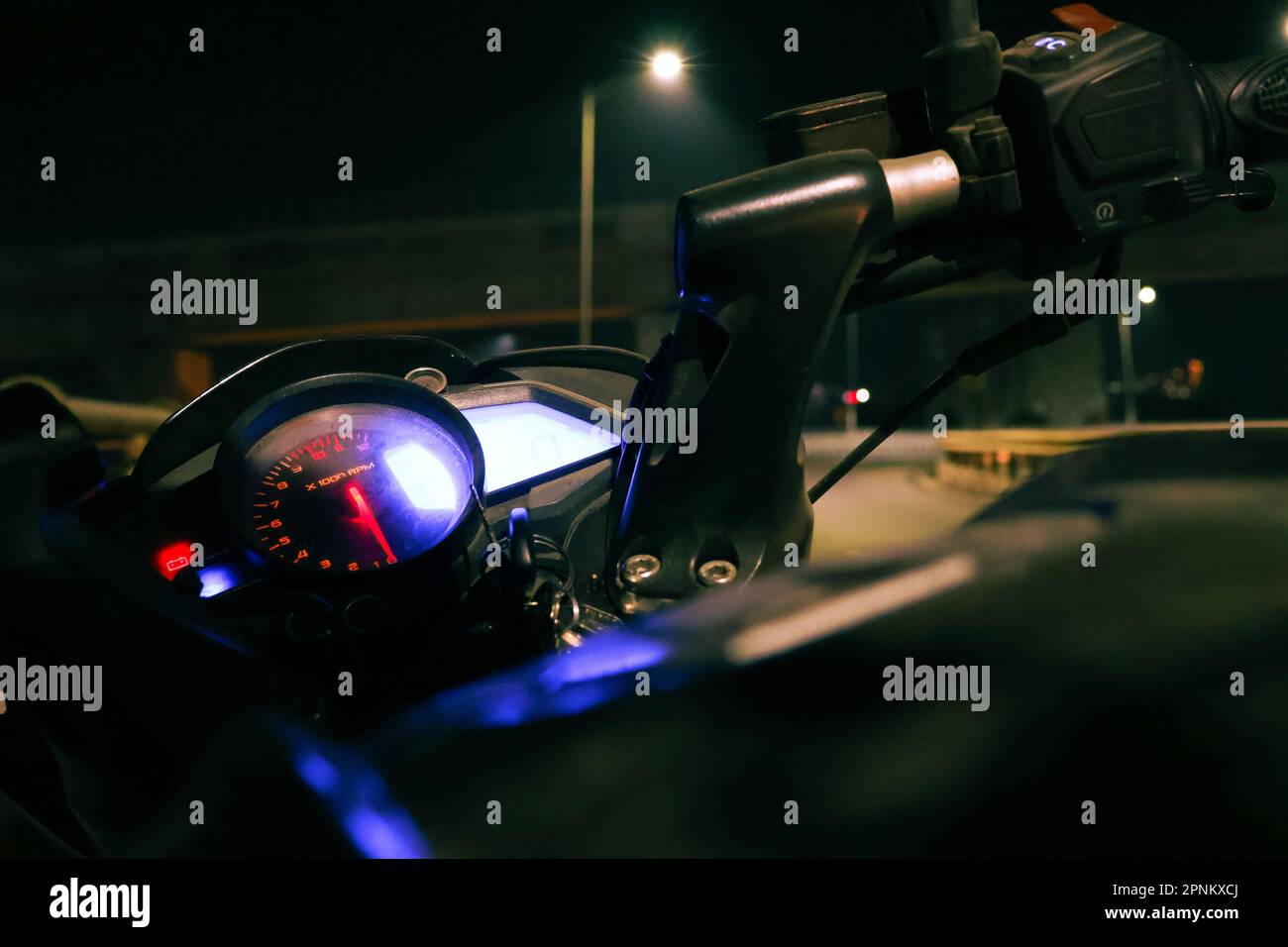 An image of a motorcycle dashboard featuring illuminated instrumentation and controls Stock Photo