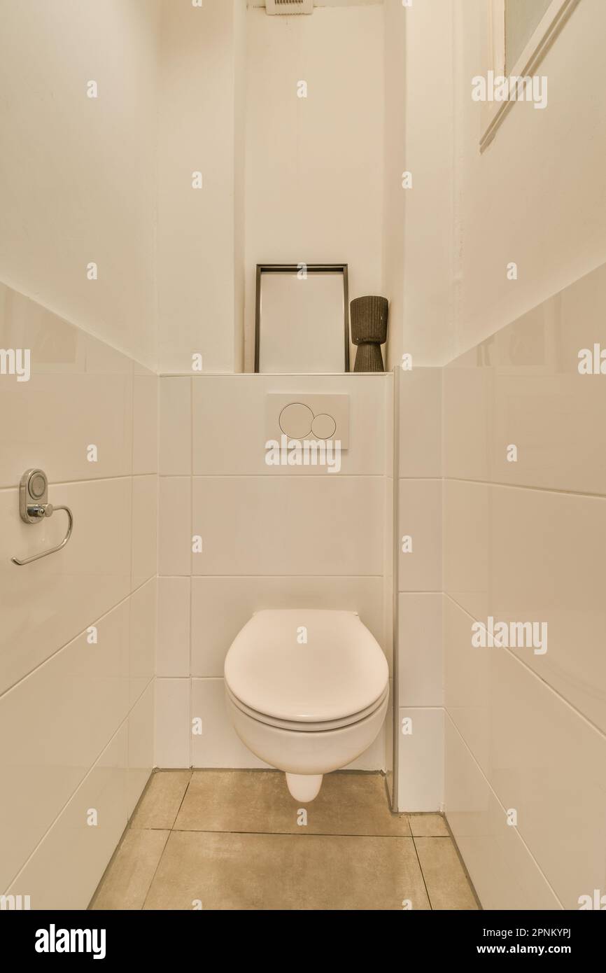 a white toilet in a bathroom with tile flooring and wall mounted mirror