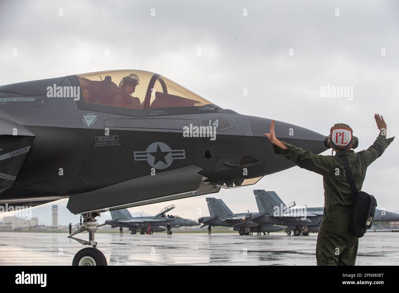 U.S. Marine Corps Cpl. Dylan Chavez, a fixed-wing aircraft mechanic with Marine Fighter Attack Squadron 242, guides an F-35B Lightning II aircraft with VMFA-242 at Marine Corps Air Station Iwakuni, Japan, April 12, 2023. Marines with Marine Aircraft Group 12 and U.S. Navy Sailors with Carrier Air Wing Five conducted a joint, live missile shoot over the Pacific to sustain their high-level of weapon proficiency, while serving as forward-postured aviation units in the Indo-Pacific region. (U.S. Marine Corps photo by Sgt. Jose Angeles) Stock Photo