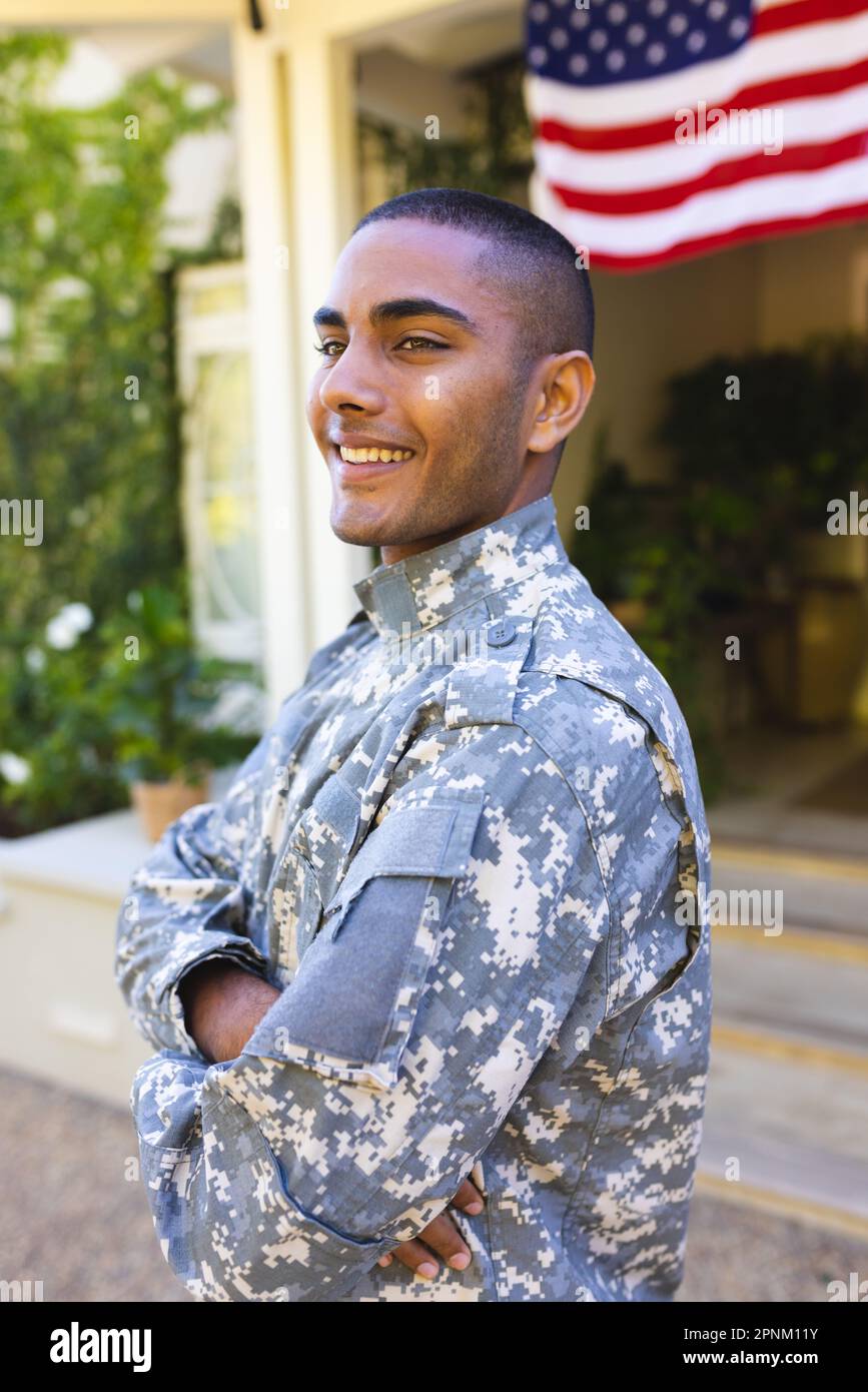 Happy biracial male american soldier wearing military uniform standing