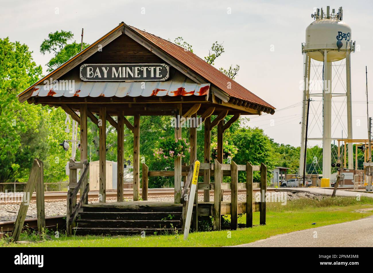A rustic wooden platform stands alongside the railroad tracks near the