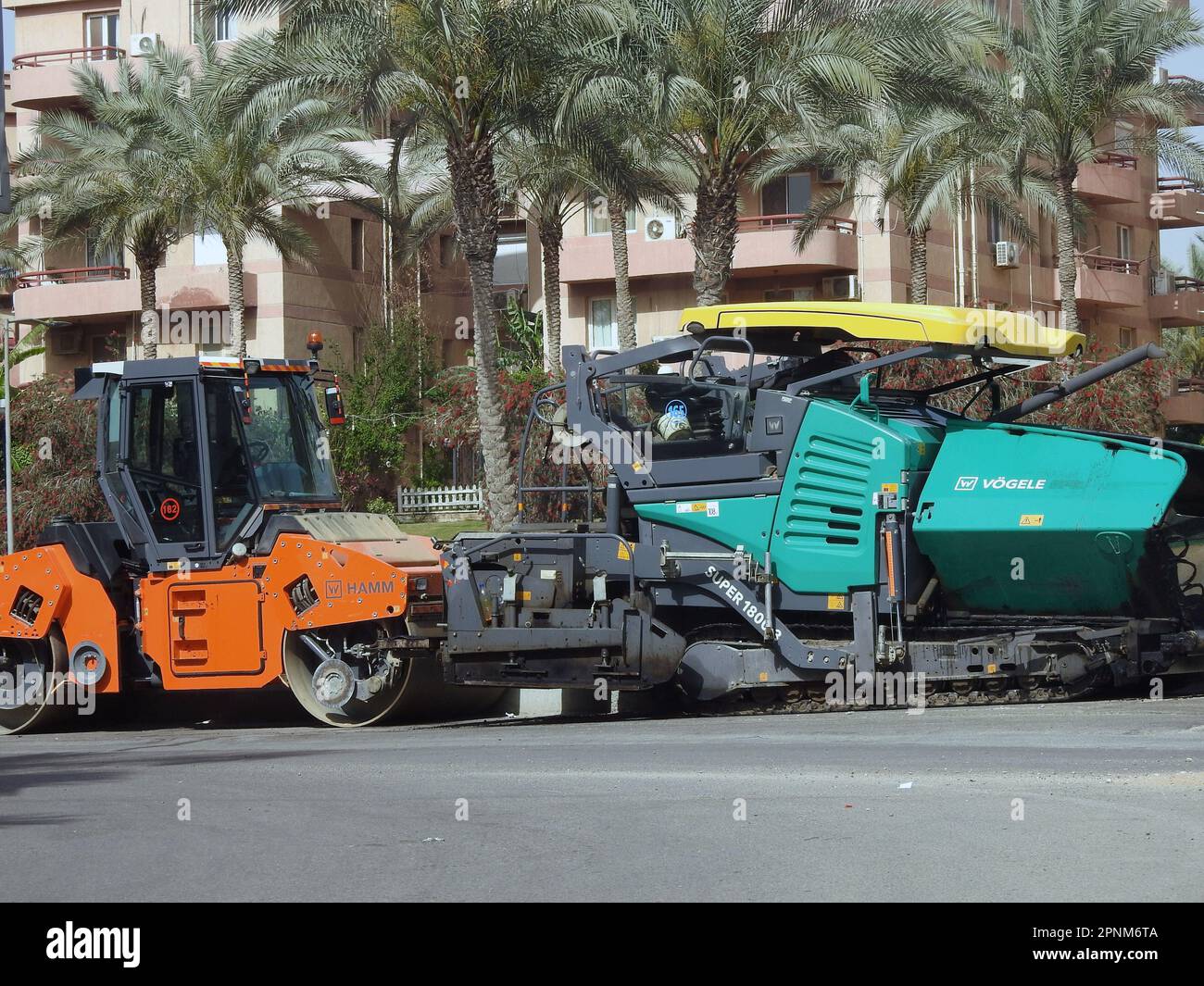 Cairo, Egypt, April 18 2023: Asphalt paver trucks and compactors, A paver (road paver finisher, asphalt finisher, road paving machine) is a piece of c Stock Photo