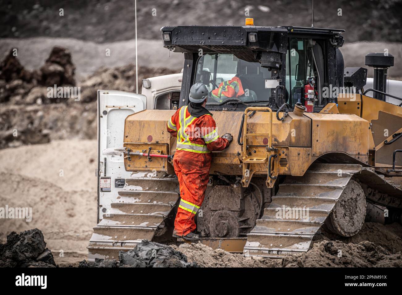 Heavy machinery mechanic checking a bulldozer at a construction site