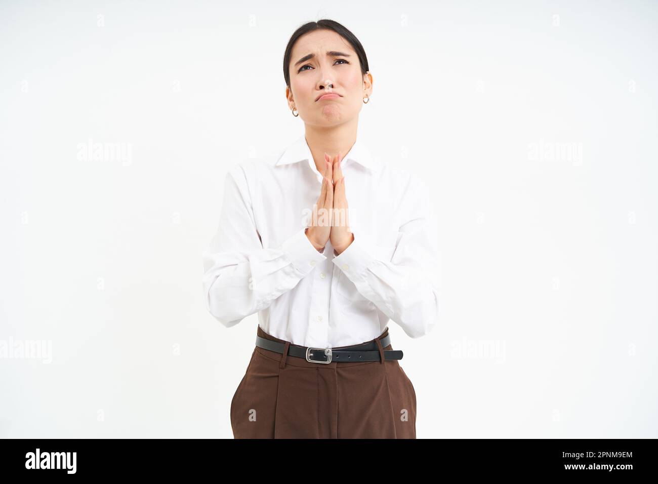 Sad asian woman pleading, looks up at Lord with hands in pray, begging ...