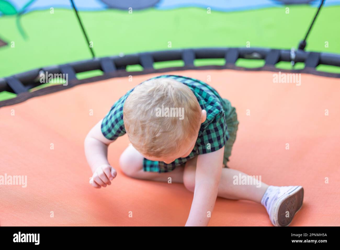 Preschool age child playing on trampoline in a vibrant fun outdoor