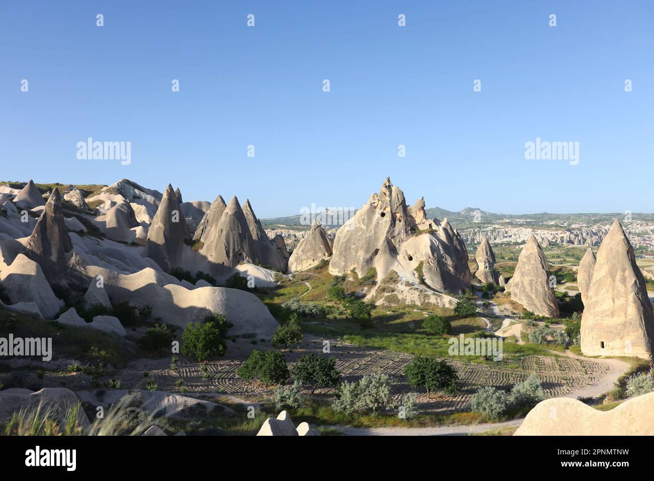 Mountainous landscape with cone-shaped rocks under blue sky Stock Photo ...