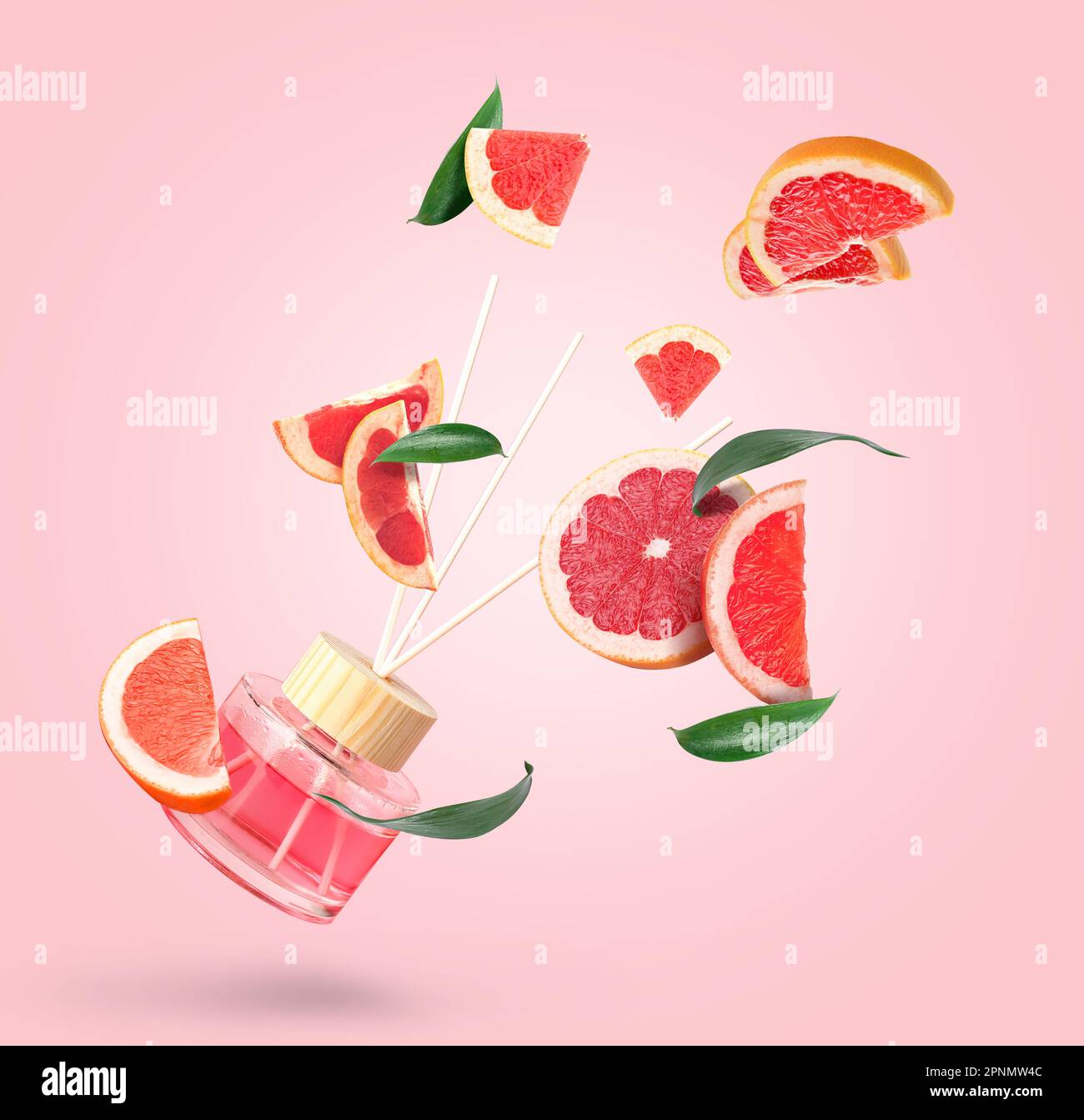 Reed diffuser with grapefruit slices on pink background Stock Photo