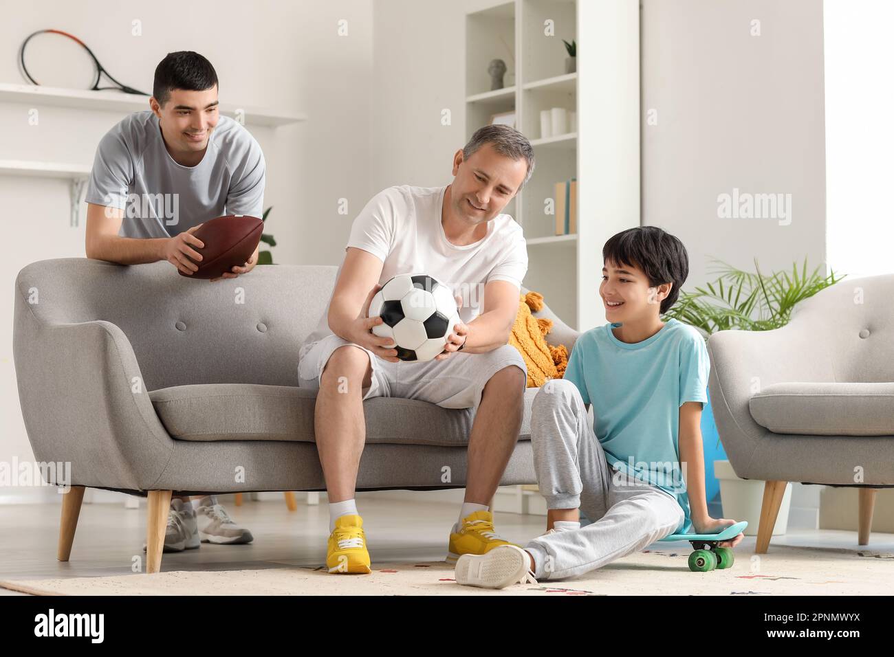 Sporty little boy with his dad and grandfather at home Stock Photo - Alamy