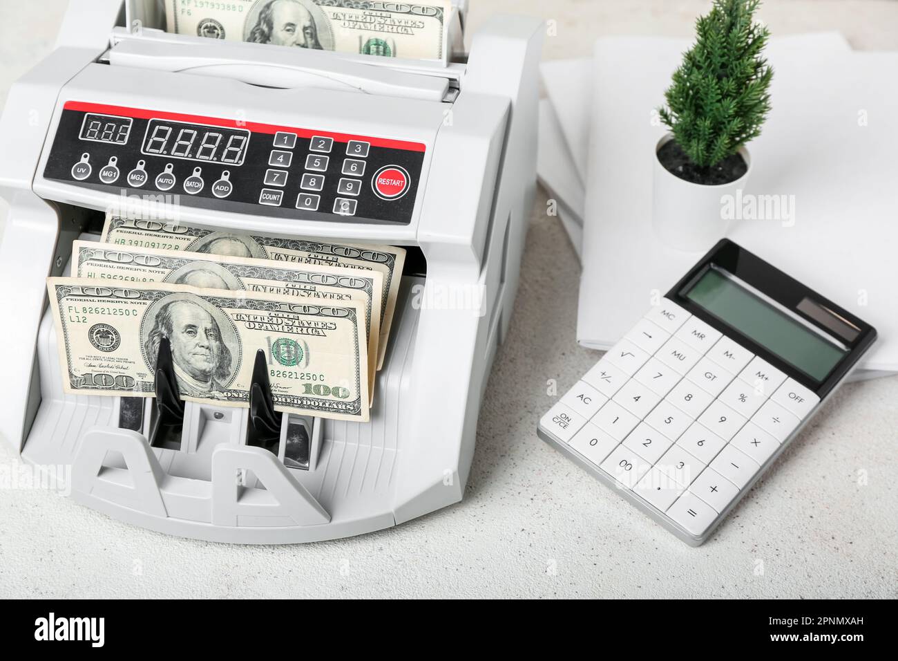 Modern cash counting machine with dollar banknotes and calculator on ...